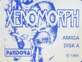 Top of cartridge artwork for Xenomorph on the Commodore Amiga.